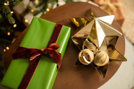 A green box with a gift stands against the background of a Christmas treeの写真素材
