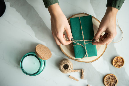 Hands creating Christmas decorations from recycled green materialsの写真素材