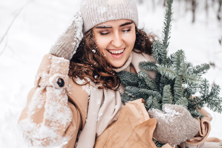 Snow on the face of a young woman, laughing with her eyes closed and holding a nobilisの写真素材