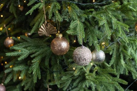 New Year's golden toys and balloons hang on a green Christmas tree with a garlandの写真素材