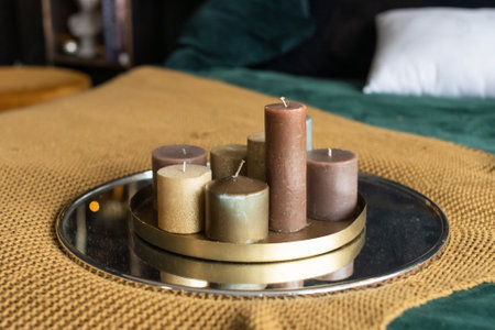 A tray with a set of candles stands on a bed with a blanketの写真素材