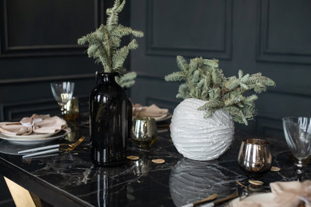 Christmas interior, fir branches in vases on the table. Dining table with platesの写真素材