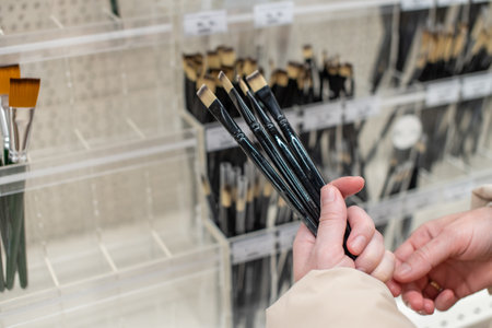 A woman in an art store holds a natural brush in her handsの写真素材