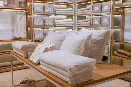 A set of white bedding is on the shelf in the store. Pillow and blanket are for saleの写真素材