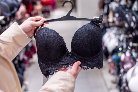 Holding a lacy black bra in the store on a hangerの写真素材