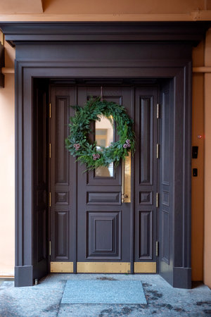 The wooden entrance door is decorated with a Christmas wreathの写真素材