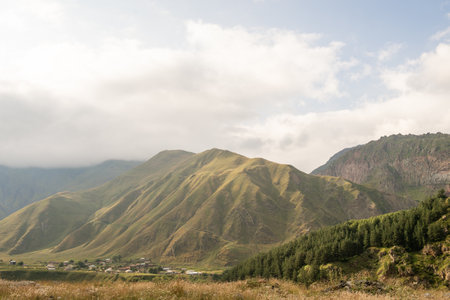 High mountains and nature on the Georgian military road. A small settlement near the mountainの写真素材
