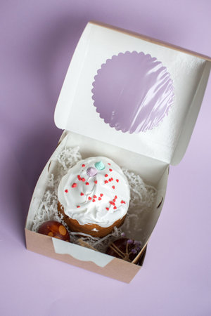 Easter cake kraffin in icing sugar is in a box with red eggsの写真素材