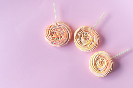Pink round sweet meringues lie on a pink backgroundの写真素材