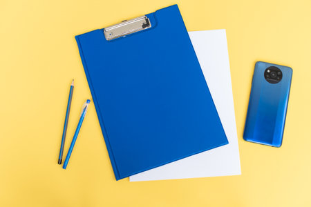 A blue stationery set as a template with a place to copy on a yellow background with a blue phone.の写真素材