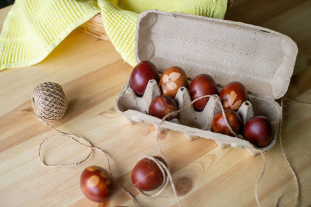 Painted eggs cooked for Easter are in an eco-friendly tray near the towelの写真素材