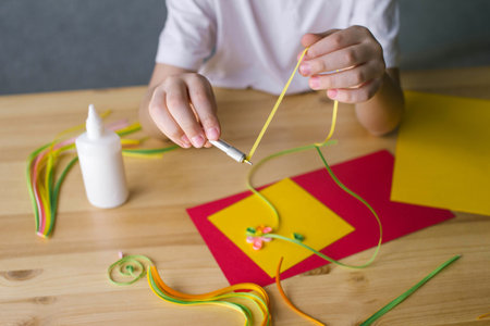 The child's hands make a card out of quilling, Twist a strip of paper with an awlの写真素材