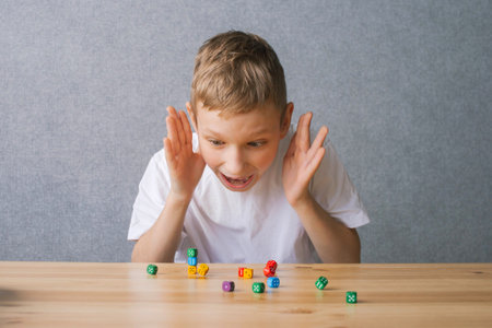 Little boy sitting at the table and playing with wooden cubes with lettersの写真素材