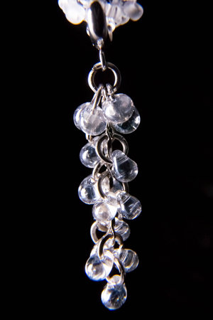 Pendant for a necklace made of white small beads on a black backgroundの写真素材