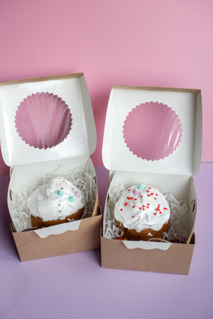 Cupcakes in paper box on pink background. copyspace.
