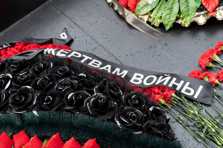 A wreath with a mourning black ribbon for the victims of the war is laid on the monument to the heroesの写真素材