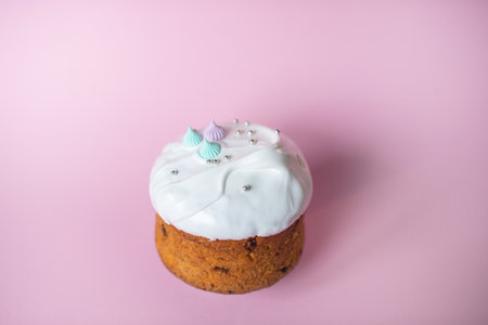 Festive cake in white glaze with decorations on a pink backgroundの写真素材