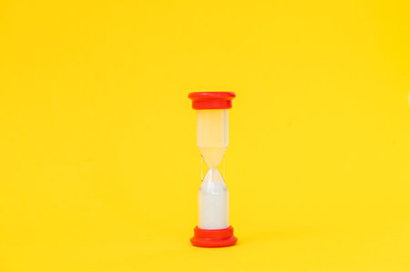 An hourglass from a board game on a yellow background. Space for text, copy spaceの写真素材