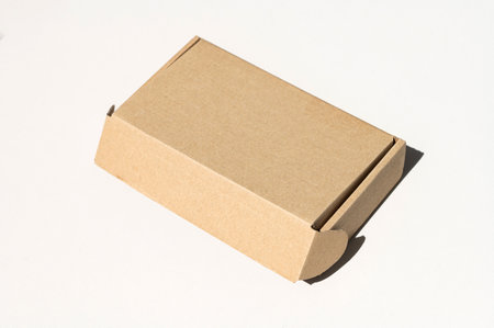 Rectangular closed box made of corrugated cardboard on a white background. Top view of a cartoon...