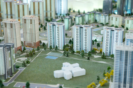 A miniature city on the table. Layout of a block with a residential building. Layout of a residential development with a parkの写真素材
