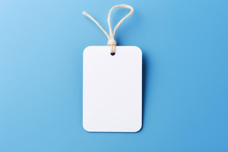 A mock-up of a white empty tag with a rope on a blue background. Place for textの素材