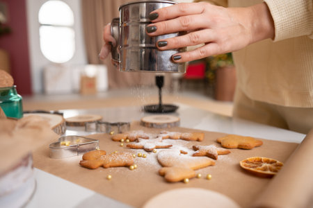 The woman's hands are sprinkled with powdered sugar gingerbread. Festive pastriesの写真素材