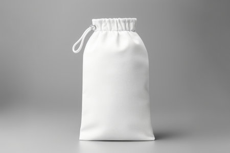 White silk cloth bags with laces for jewelry stand on a table with stonesの素材