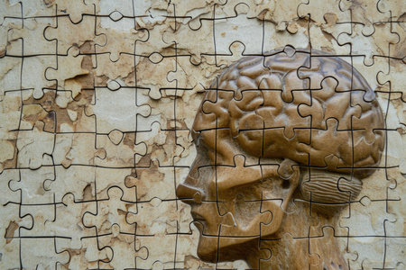 Jigsaw puzzle pieces forming a human brain on a textured backgroundの素材