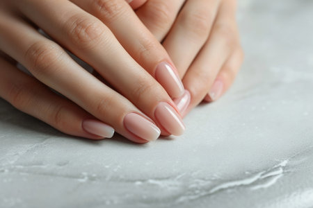 Close-up of well-manicured hands, subtle pink nail polishの素材