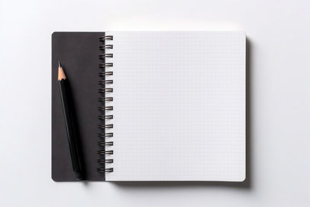 A clean, open grid-lined notebook beside a sharp pencil, ready for notesの素材