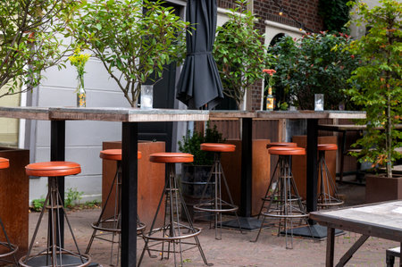 Outdoor bar scene with wooden high tables and leather stoolsの写真素材