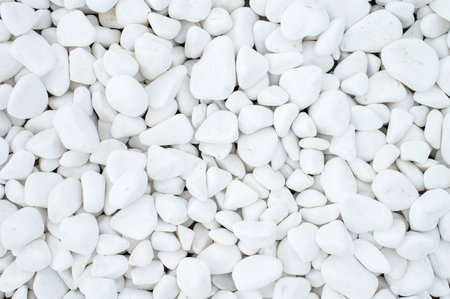 Pure texture of white pebbles. Small stones on the ground. Top view of the natural colorful gravel on the summer beachの写真素材