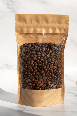 A brown kraft paper bag with a coffee bean lock for viewing with a highlighted shadow on a white background. Layout of the packaging template for food and essential goods.の写真素材