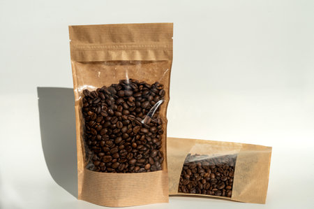 A brown kraft paper bag with a coffee bean lock for viewing with a highlighted shadow on a white background. Layout of the packaging template for food and essential goods.の写真素材