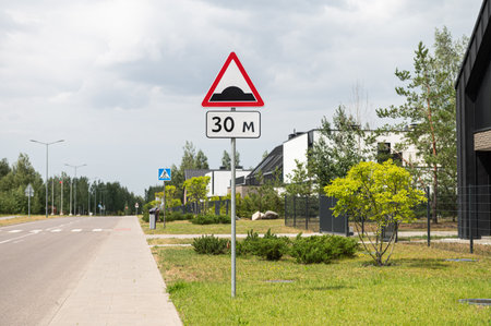 Traffic sign warning of a speed bump ahead with a pedestrian crossing in an urban areaの写真素材