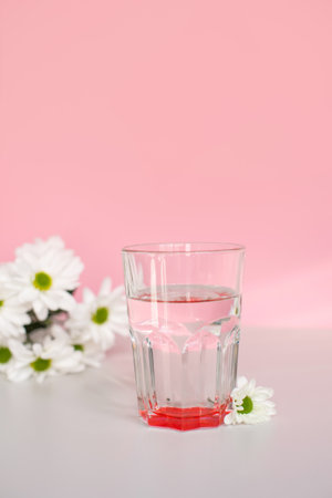 Clean drinking water in a transparent glass in the morning sun is on the tableの写真素材