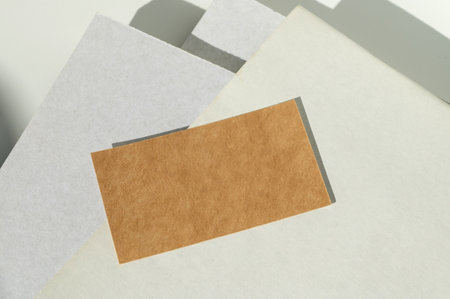 A simple yet elegant composition of layered paper with varying textures, highlighted by soft natural sunlight and geometric shadowsの写真素材