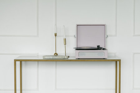 A contemporary minimalist living space featuring a stylish vinyl player and elegant candles on a sleek console tableの写真素材