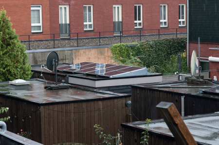 Wet rooftops of suburban houses equipped with solar panels on a rainy dayの写真素材