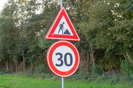 Road signs indicating construction and a 30 km/h speed limitの写真素材