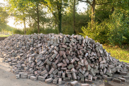A large pile of stacked bricks ready for construction on the roadsideの写真素材