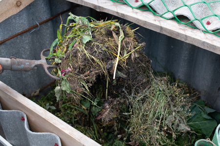 A close-up view of a garden fork lifting organic compost material in a sustainable home garden...