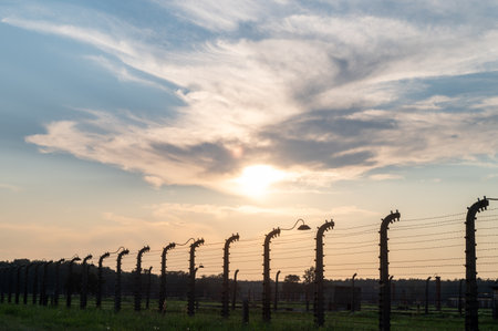 Sunset view of barbed wire fence with dramatic clouds in the sky. Landscape photography of a boundary in a fieldの写真素材