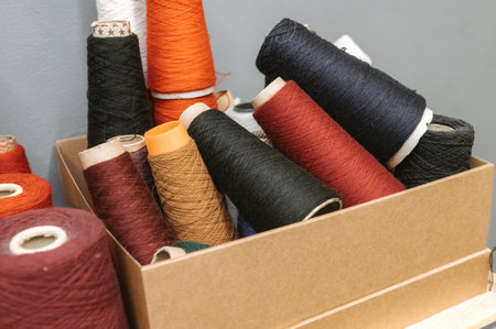 Colorful collection of sewing threads and cones for tailoring projects.