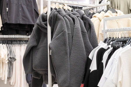 Explore the cozy collection of jackets featuring different styles and textures, neatly displayed for shoppers in a clothing storeの写真素材