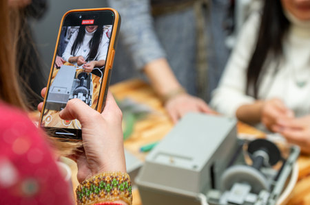 Female capturing educational workshop with smartphone.の写真素材