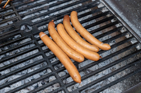 A selection of sausages cooking evenly on a classic barbecue grill, capturing the essence of outdoor cookingの写真素材