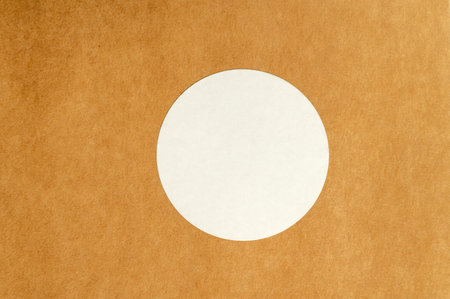 White round sticker on brown textured surface. Minimalistic product label conceptの写真素材