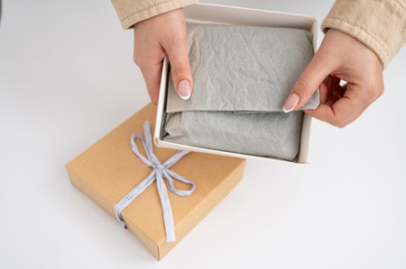 Female hands opening gift box with bow.