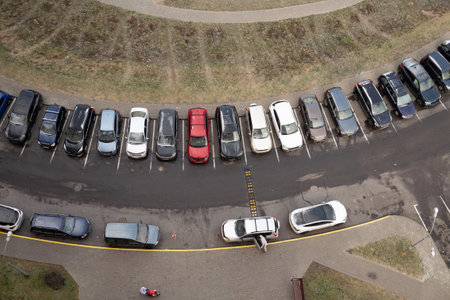 Aerial view of cars parked in a row near sidewalk on circular path.の写真素材